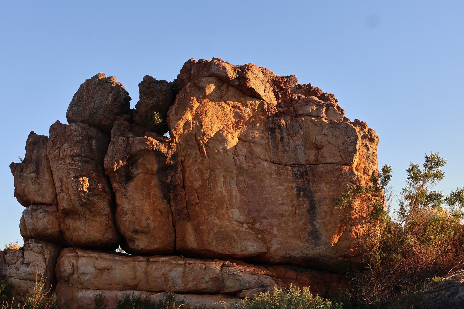 A sandstone boulder above Citrusdal lit orange at sunset