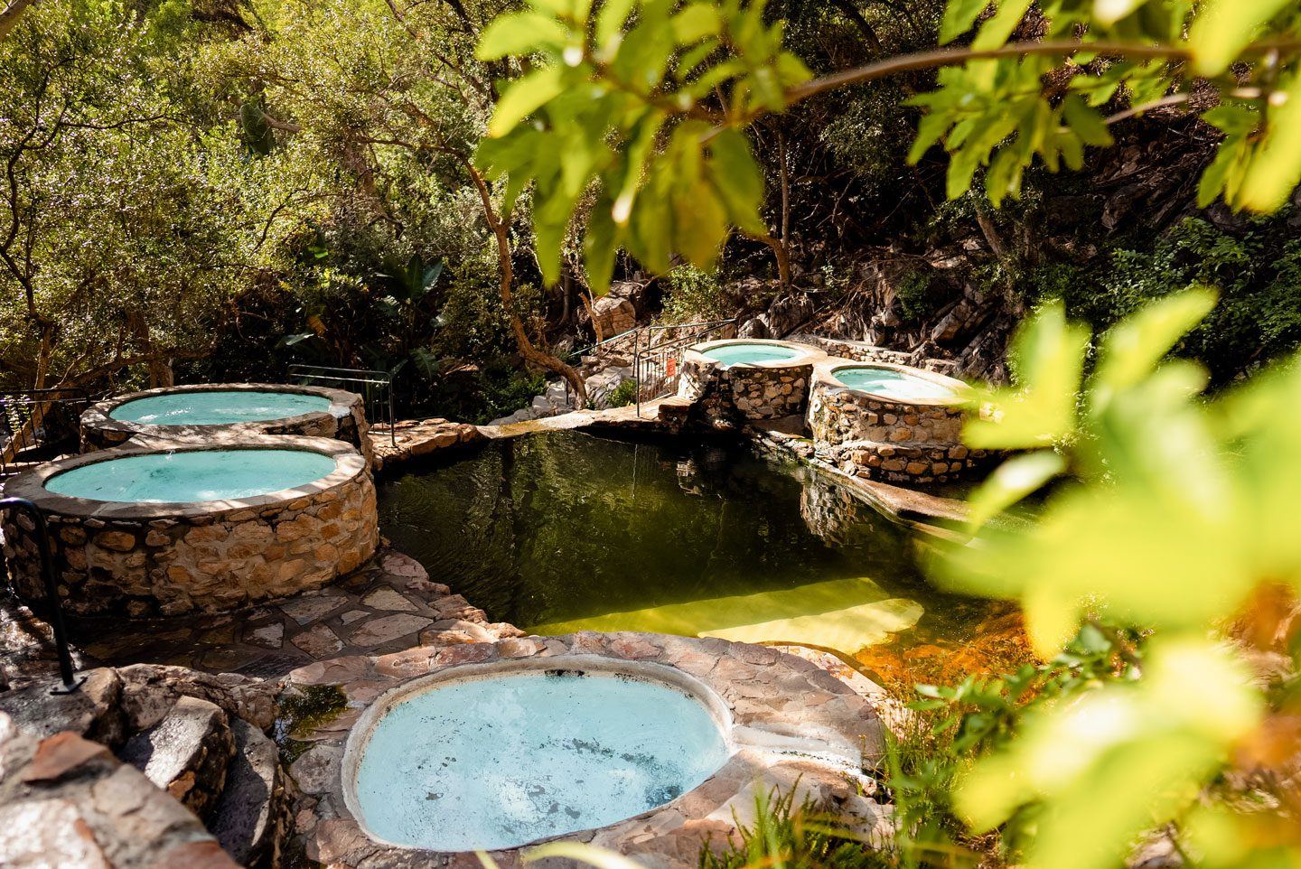 Round stone hot-spring pools among the trees in the kloof at The Baths, Citrusdal