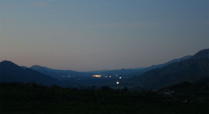Citrusdal spread across the valley floor at dusk, seen from the Cederberg slopes above it.