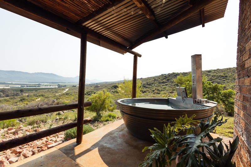A wood-fired hot tub on the covered stoep of Boegoe house, looking out over the valley.