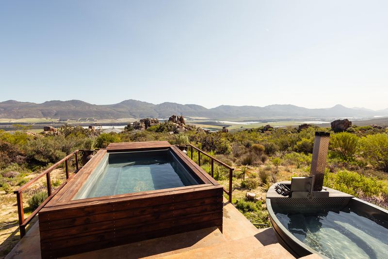 A raised plunge pool beside the hot tub at Waboom house, with the valley and mountains beyond.